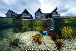 A diver in front of some houses in Vesterålen, Norway by Rune Edvin Haldorsen 